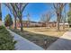 Apartment building featuring a spacious lawn area with mature trees and walkway at 2201 S Holly St # 1, Denver, CO 80222