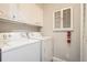 Functional laundry room with washer, dryer, built-in cabinets and a safety fire extinguisher at 2201 S Holly St # 1, Denver, CO 80222