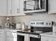 Close up of kitchen featuring stainless steel appliances, white backsplash, and white countertops at 2721 W 167Th Pl, Broomfield, CO 80023