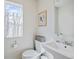Bright powder room featuring a pedestal sink, toilet, and window with natural light at 2721 W 167Th Pl, Broomfield, CO 80023
