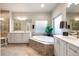 Bathroom with tub, double sinks and vanity, and tiled shower at 16113 Enchanted Peak Way, Monument, CO 80132