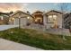 Inviting home boasts a well-manicured lawn, a two-car garage, and stone architectural detailing at 16113 Enchanted Peak Way, Monument, CO 80132