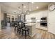 Modern kitchen featuring an island with bar seating, pendant lights and a dining area at 16113 Enchanted Peak Way, Monument, CO 80132