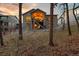 This home's rear exterior has a covered patio and stairs leading to a gravel yard and woodland views at 16113 Enchanted Peak Way, Monument, CO 80132
