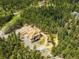 Stunning aerial view of a home with a circular driveway surrounded by a dense forest at 30041 Marys Dr, Conifer, CO 80433