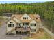 Gorgeous view of the back of the home, including a large deck and multiple windows and glass doors at 30041 Marys Dr, Conifer, CO 80433