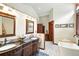 Elegant bathroom with double vanities, soaking tub, and wood trim throughout at 30041 Marys Dr, Conifer, CO 80433