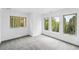 Bright bedroom featuring three windows and neutral carpeting at 30041 Marys Dr, Conifer, CO 80433