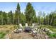 Circular gravel firepit area with seating, surrounded by mature trees at 30041 Marys Dr, Conifer, CO 80433