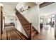 Foyer featuring hardwood floors, a staircase with metal spindles, and a view into the kitchen at 30041 Marys Dr, Conifer, CO 80433