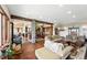 Open concept floor plan with hardwood floors, a stone pillar and a view to the kitchen and dining room at 30041 Marys Dr, Conifer, CO 80433
