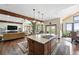 Open-concept living and kitchen area with a large island, hardwood floors, and wood-burning stove at 30041 Marys Dr, Conifer, CO 80433