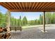 Rear porch with a hanging bench swing and wooded views at 30041 Marys Dr, Conifer, CO 80433