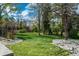 Serene backyard oasis featuring mature trees, lush green lawn, and rock landscaping, perfect for relaxation at 4285 S Hudson Pkwy, Englewood, CO 80113