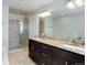Bathroom featuring a double vanity, granite countertops, and tiled walk-in shower at 3040 Zuni St # F, Denver, CO 80211