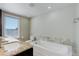 Bright bathroom featuring a soaking tub and a large window at 3040 Zuni St # F, Denver, CO 80211
