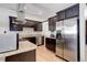 Modern kitchen featuring stainless steel refrigerator, dark cabinetry, and granite countertops at 3040 Zuni St # F, Denver, CO 80211