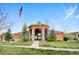 Attractive clubhouse entrance with an American flag on a clear day, stone accents and manicured lawn at 4500 Copeland Cir # 104, Highlands Ranch, CO 80126