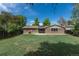 Beautifully maintained backyard with a well-kept lawn, brick home, and clear blue sky at 2120 S Ouray St, Aurora, CO 80013