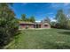 Spacious backyard with lush green grass and mature trees, presenting a serene outdoor setting at 2120 S Ouray St, Aurora, CO 80013