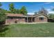 Backyard view of a brick house with solar panels on the roof and a well-maintained lawn at 2120 S Ouray St, Aurora, CO 80013