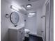 Modern bathroom featuring a round mirror, stylish vanity, and sleek shower with black accents at 2120 S Ouray St, Aurora, CO 80013