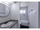 Modern bathroom with granite countertop, round mirror, and a shower-tub with white subway tile at 2120 S Ouray St, Aurora, CO 80013