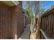 Side exterior view of a brick home with a walkway and a wooden fence, showcasing its classic architecture at 2120 S Ouray St, Aurora, CO 80013