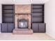 Traditional brick fireplace framed by custom built-in bookshelves in a cozy living space at 2120 S Ouray St, Aurora, CO 80013