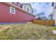 Side view of backyard with grass, a privacy fence, and red siding at 10136 Worchester St, Commerce City, CO 80022
