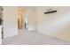 Spacious bedroom with plush carpet, featuring a shelf and open doorway to another room at 10136 Worchester St, Commerce City, CO 80022