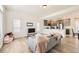 Bright living room with wood floors that flows into kitchen featuring sleek gray cabinets at 10136 Worchester St, Commerce City, CO 80022