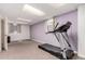 A finished basement area with a treadmill, neutral carpet, and natural light from a window at 10720 Moore Cir, Westminster, CO 80021