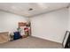 Unfinished basement storage area with neutral carpet, personal belongings, and visible ceiling at 10720 Moore Cir, Westminster, CO 80021