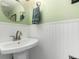 A bright bathroom featuring a pedestal sink and white wainscoting at 10720 Moore Cir, Westminster, CO 80021