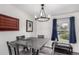 Bright dining area features a wooden table with chairs, pendant lighting, and a window with blue curtains at 10720 Moore Cir, Westminster, CO 80021