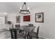 Cozy dining room featuring a modern chandelier, a wooden table with four chairs, and stylish decor at 10720 Moore Cir, Westminster, CO 80021