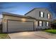 Charming two-story home features a two-car garage, blue shutters, well-maintained lawn, and mature trees at dusk at 10720 Moore Cir, Westminster, CO 80021