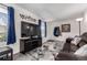 Well-lit living room featuring a large TV, comfortable sofa, gray floors, and a welcoming entryway at 10720 Moore Cir, Westminster, CO 80021