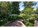 Stone steps lead to a lush backyard featuring a variety of plants and trees at 6722 S Wolff Ct, Littleton, CO 80128