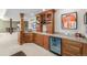 Finished basement bar with custom cabinetry, wine storage, and beverage refrigerator at 6722 S Wolff Ct, Littleton, CO 80128