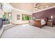 Spacious primary bedroom features a fireplace, sitting area, ceiling fan, and plenty of natural light at 6722 S Wolff Ct, Littleton, CO 80128