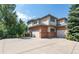 Exterior elevation with a view of the attached garages and a large driveway at 6722 S Wolff Ct, Littleton, CO 80128