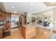 Gourmet kitchen flows to living room with stainless appliances, gas range, island with sink, and granite countertops at 6722 S Wolff Ct, Littleton, CO 80128