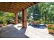 Shaded outdoor patio with comfortable seating and a view of the manicured backyard at 6722 S Wolff Ct, Littleton, CO 80128