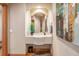 Powder room with custom mirror and lighting, art work, and a travertine sink on a wood floor at 6722 S Wolff Ct, Littleton, CO 80128