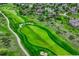 Aerial view of a lush golf course with manicured greens, sand traps, and walking path at 5424 Hacienda Pl, Parker, CO 80134