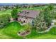 Aerial view of a house with a lush lawn and a stone patio with comfortable furniture at 5424 Hacienda Pl, Parker, CO 80134