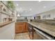 Basement bar area featuring wood cabinets, granite countertop, and glass shelving at 5424 Hacienda Pl, Parker, CO 80134