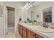 Charming bathroom featuring dual sinks, warm lighting, and tiled backsplash at 5424 Hacienda Pl, Parker, CO 80134